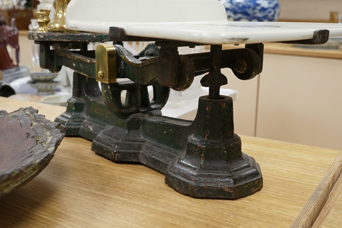 A set of Victorian iron and ceramic scales and seven brass weights, 53cm wide